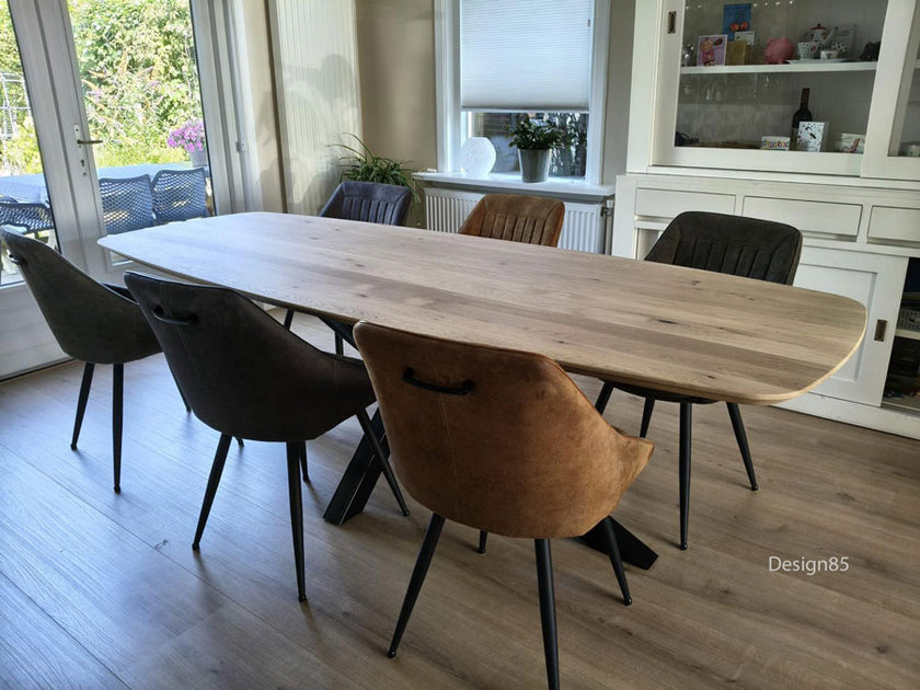 Eettafel Deens Ovaal Fjord van licht eikenhout met zwart stalen onderstel in een moderne eetkamer met zes stoelen.