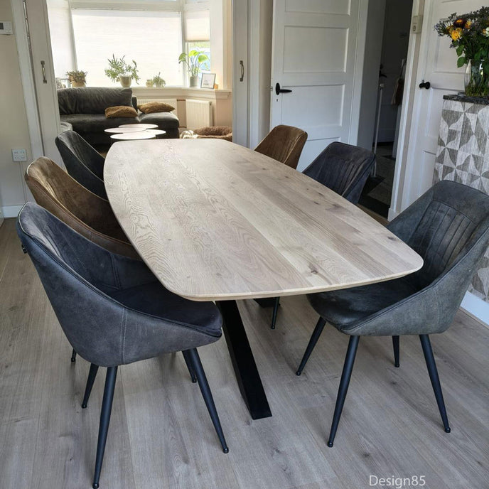Design85 Eettafel Deens Ovaal Fjord met massief houten blad en zwart metalen poot, stijlvol geplaatst in een lichte woonruimte.