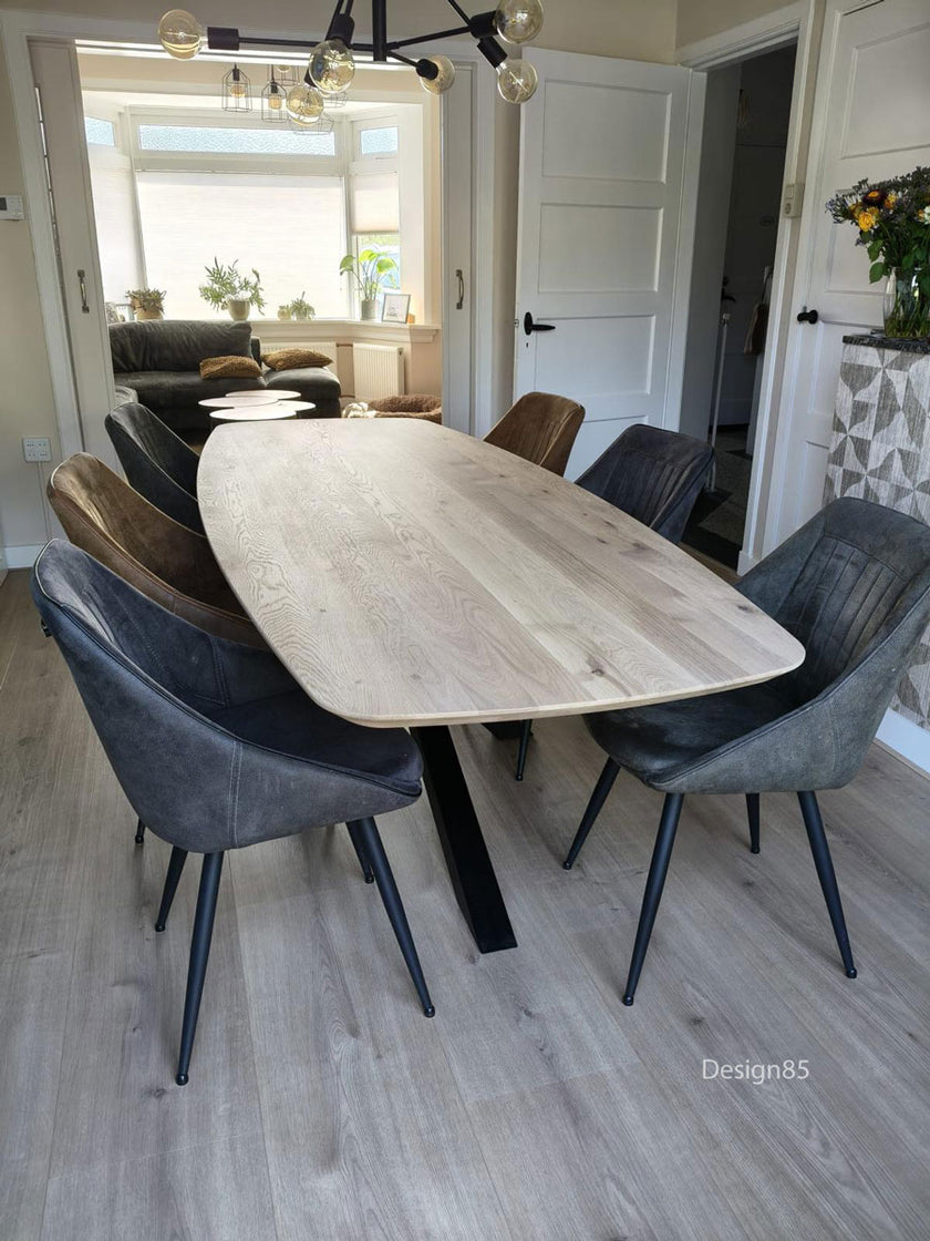 Design85 Eettafel Deens Ovaal Fjord met massief houten blad en zwart metalen poot, stijlvol geplaatst in een lichte woonruimte.