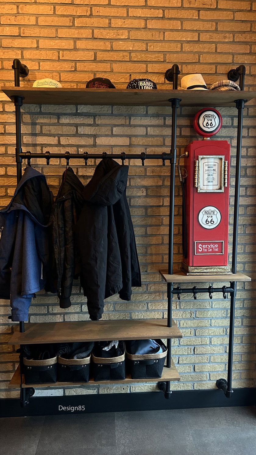 industriele kapstok stralend met een stenen muur en hoeden op de bovenste legplank.