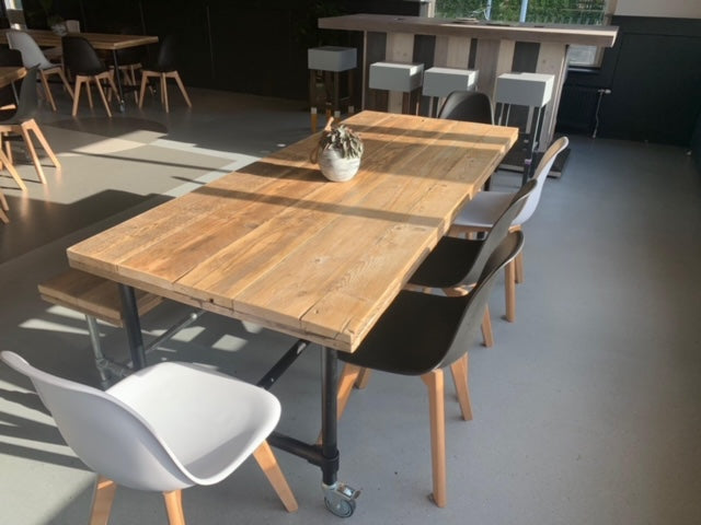 Steigerbuis tafel met oud steigerhouten blad en zwart stalen onderstel in industriële stijl.