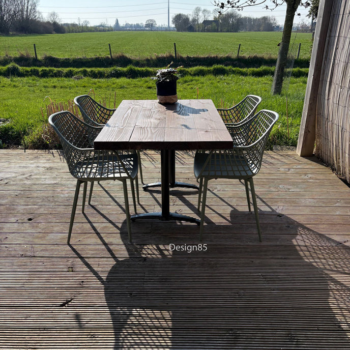 Houten horeca tafel met stalen poot op terras met tuin en bamboe schutting
