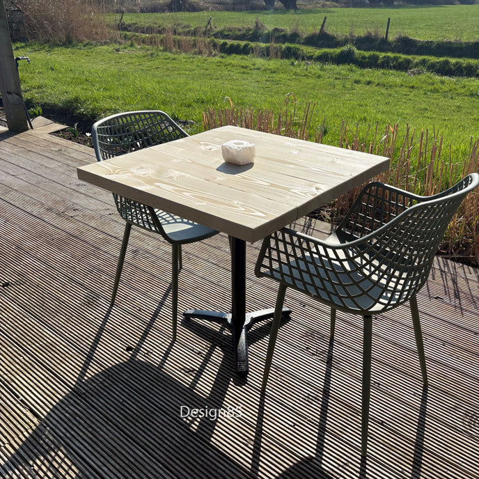 Houten bartafel met zwart metalen onderstel in een sfeervolle achtertuin met gezellige zithoek.
