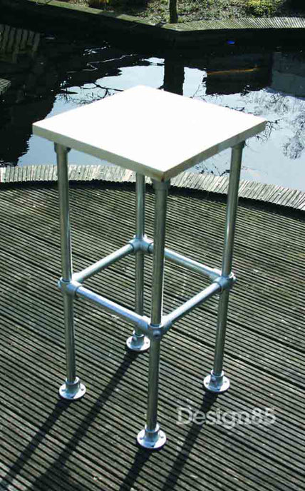 industriele barkruk buiten die op een vlonder staat met er achter een vijver.