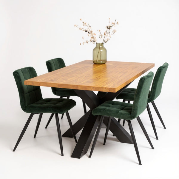 Industriële eiken eettafel Vulkaan met zwart stalen kruispoot en eiken tafelblad in naturel kleur, gecombineerd met groene eetkamerstoelen.