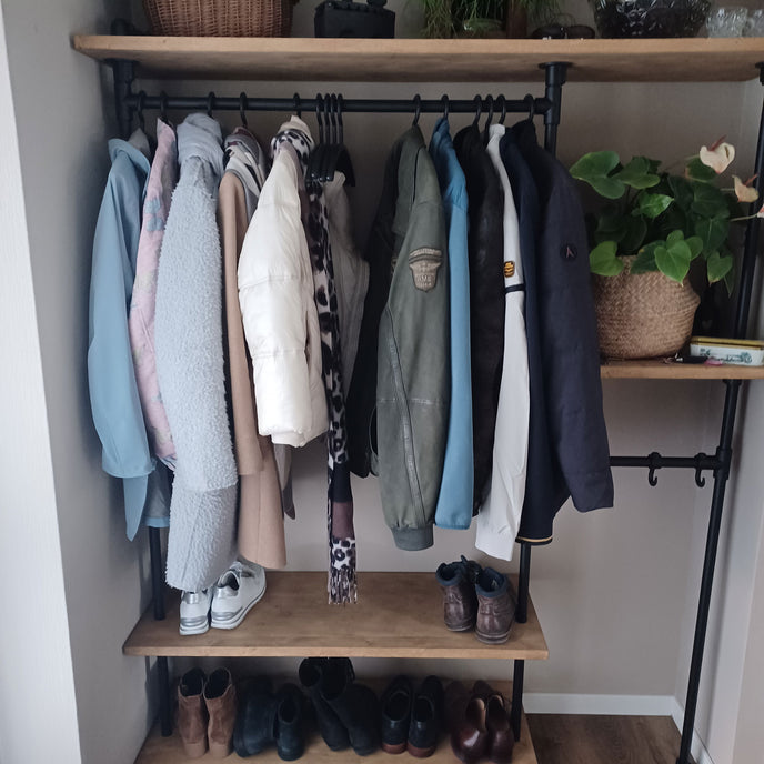 industriele kapstok parade met jassen en schoenenplank.