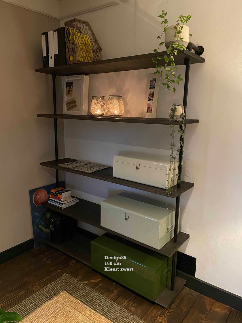 Open industriële vakkenkast met zwarte legplanken, decoratie en planten in modern interieur