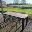Grote tuintafel van douglas hout met industrieel stalen frame en tuinstoelen