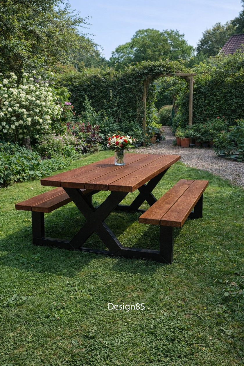 Industriële picknicktafel met houten blad, bijpassende banken en zwart stalen onderstel in een groene tuin.