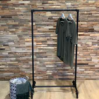 Industrieel kledingrek op wielen van zwart staal met twee shirts aan kledinghangers en een robuust buizenframe