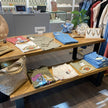 Presentatietafel winkel van hout en zwart staal met kleding en accessoires in een kledingzaak.