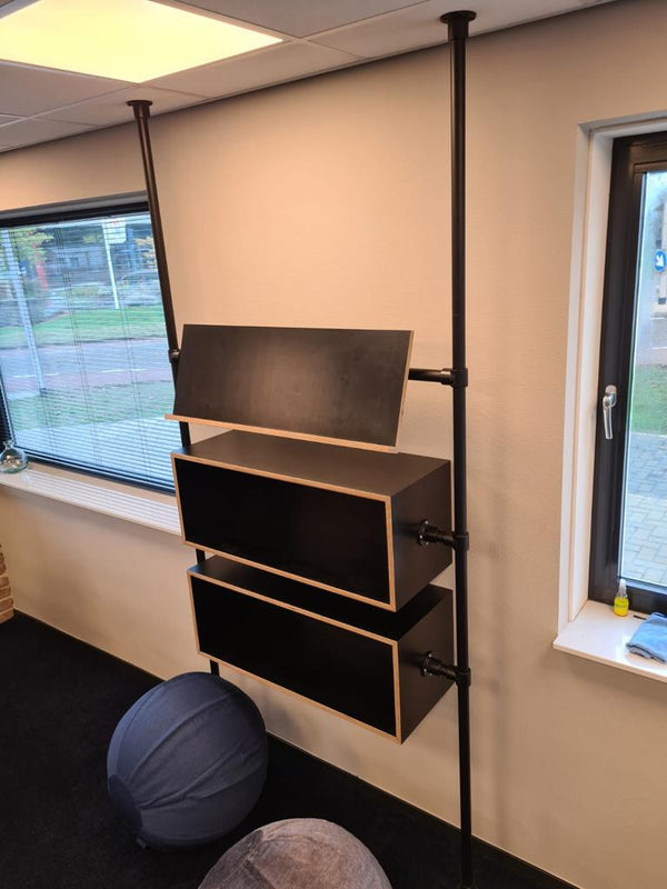 Steigerbuis kast voor op kantoor met zwarte steigerbuizen en diverse schappen waar folders op gepresenteerd kunnen worden.