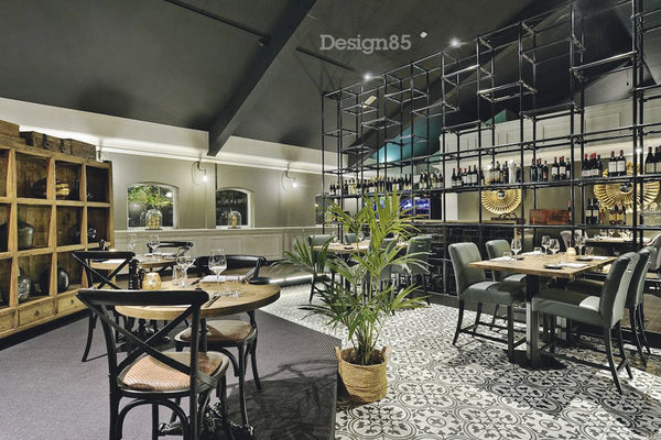 Steigerbuis wandframe met zwarte steigerbuizen die is gebruikt in een restaurant als afscheiding van de bar en waar flessen wijn op staan gepresenteerd.
