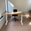Zit Sta Bureau Elektrisch van Design85 met vurenhouten bureaublad en wit in hoogte verstelbaar onderstel in een moderne kantoorruimte.
