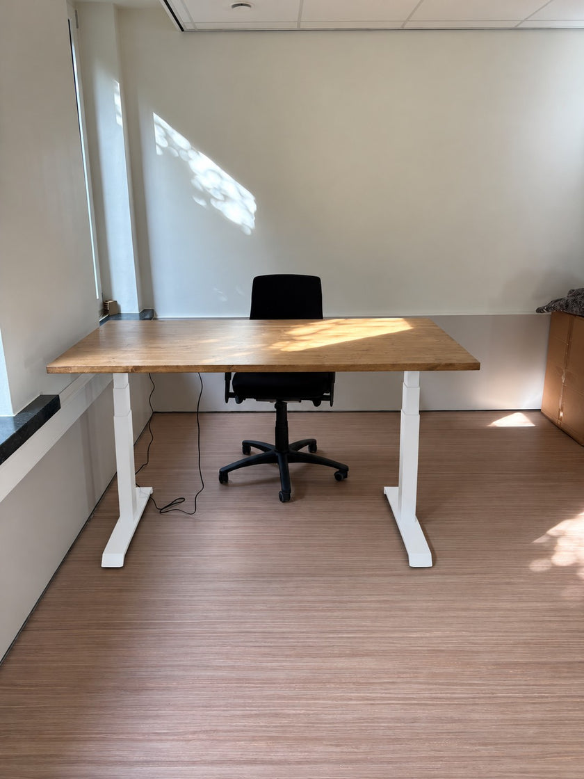 Zit Sta Bureau Elektrisch van Design85 met vurenhouten bureaublad en wit in hoogte verstelbaar onderstel in een moderne kantoorruimte.