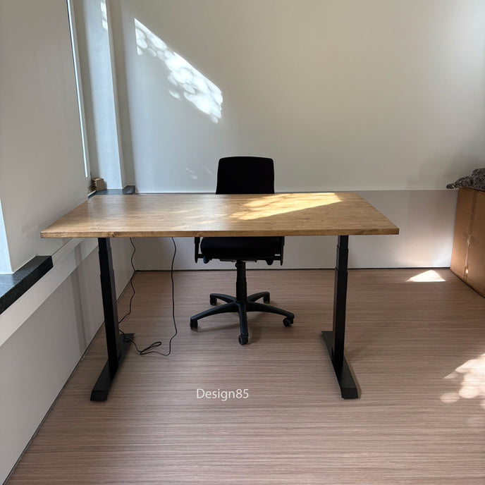 Zit sta bureau hout met natuurlijk houten bureaublad en zwart verstelbaar onderstel in een lichte kantoorruimte.