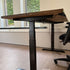 In hoogte verstelbaar zit sta bureau hout van Design85 met natuurlijk houten blad in een modern kantoor.